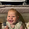 baby, child, infant, smiling, grinning, portrait, sitting, playpen, indoors, home, bedding, blanket, clothing, drawer, nursery, zipper, patterned_outfit, star_pattern, happy, closeup