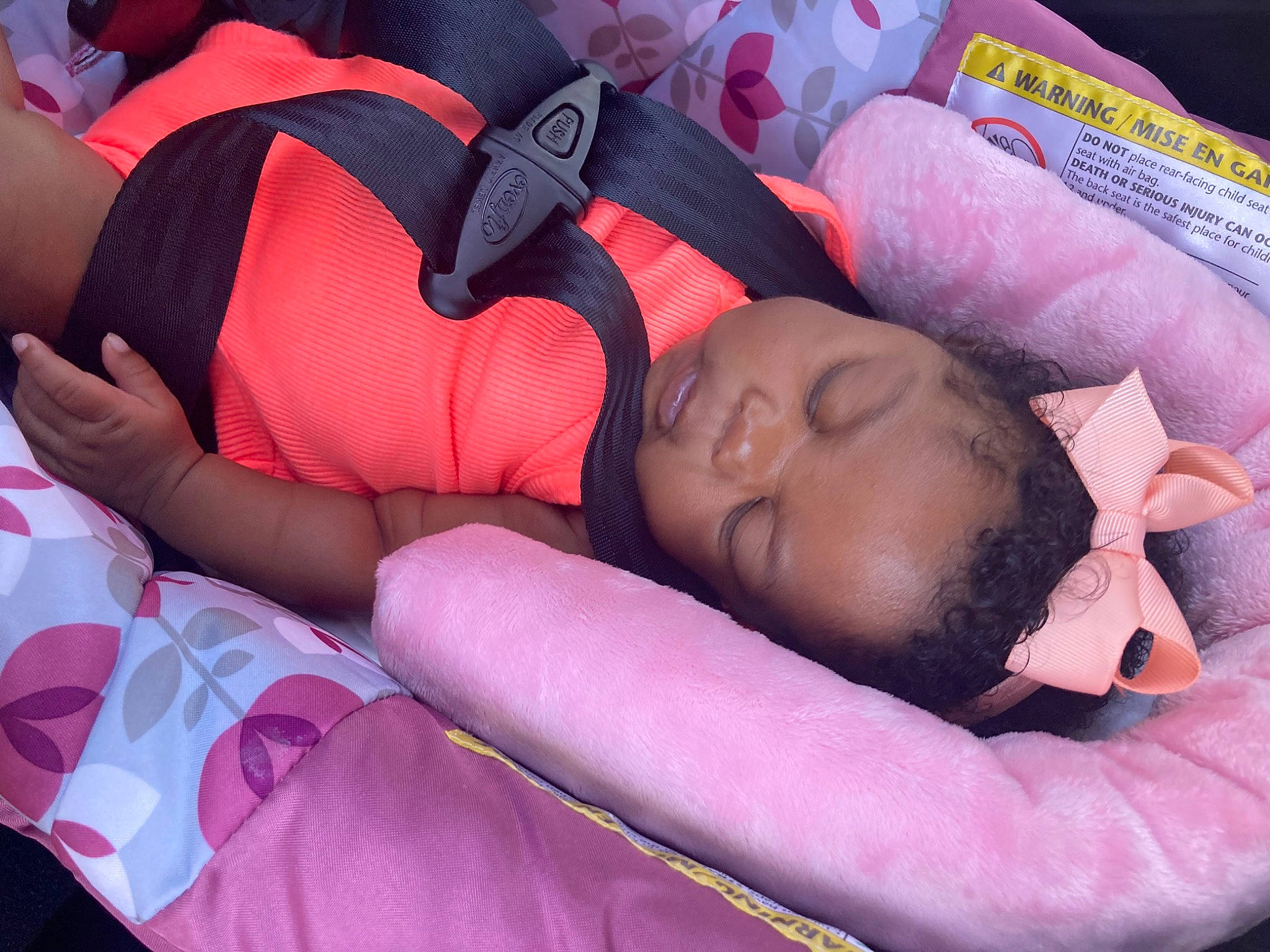 Naomi is registered to the contest to win money with this photo: arm, baby, child, comfort, elbow, facial_expression, finger, human_body, human_leg, knee, lap, leg, linens, magenta, mouth, person, pink, purple, textile, thigh