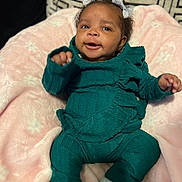 Kylie is registered to the contest to win money with this photo: baby, infant, child, smile, face, bow, hair, clothing, knitwear, blanket, pink, teal, cozy, cute, happy, indoors, portrait, sitting, soft, fabric