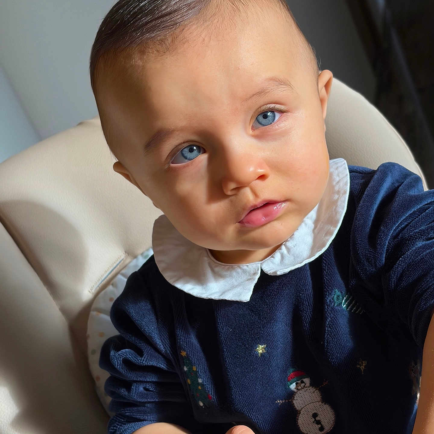 Devyns a rejoint le concours — aidez-le/la à gagner de superbes lots ! baby, blue_eyes, child, cute, curious, indoor, infant, navy_sweater, snowman, white_collar, cushioned_chair, portrait, young_child, natural_light, skin, hand, expression, clothing, person, face