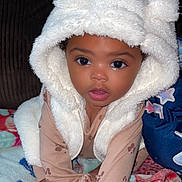 Laylani is registered to the contest to win money with this photo: baby, child, hood, white, vest, blanket, colorful, cute, face, eyes, mouth, sitting, clothing, indoor, portrait, soft, warm, infant, person, closeup