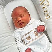 Santino is registered to the contest to win money with this photo: animal_pattern, baby, bed, closed_eyes, comfort, cozy, cushion, cute, embroidery, fabric, face, hands, infant, newborn, onesie, peaceful, rest, sleeping, soft, white