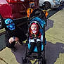 child, baby, costume, pirate, mask, skull, halloween, stroller, parking_lot, sidewalk, car, red_car, black_hoodie, outdoor, night, holiday, fun, kids, crouching, curious