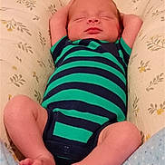 Joseph joined the competition — help win amazing prizes! newborn, baby, infant, sleeping, portrait, striped_onesie, green_clothing, navy_clothing, floral_bedding, cushion, blanket, lying_down, arms_up, bare_feet, toes, closed_eyes, peaceful, indoors, closeup, child