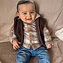 baby, casual, child, clothing, couch, cozy, cute, denim_jeans, face, happy, indoor, person, plaid_shirt, portrait, sitting, smiling, soft_texture, vest, warm_colors, young_child
