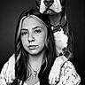 woman, person, dog, puppy, portrait, black_and_white, studio, close_up, face, animal, pet, collar, paws, shoulders, long_hair, floral_dress, serious_expression, symmetry, dramatic_lighting, photography