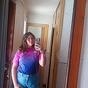 Jade a rejoint le concours — aidez-le/la à gagner de superbes lots ! person, mirror, selfie, indoor, jeans, glasses, phone, curly_hair, tshirt, door, hallway, reflection, wood_frame, casual, young_person, scrunchie, sticker, window, tile_floor, curtain