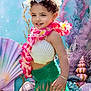 beach_sand, child, colorful, coral, costume, cute, fantasy, flower_lei, green_skirt, happy, holiday, mermaid_costume, ocean, playful, portrait, seashell_top, shells, smiling, underwater_theme, young_child