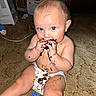 Asher is registered to the contest to win money with this photo: baby, infant, child, sitting, carpet, diaper, cookie, chocolate, food, messy, smiling, blue_eyes, face, hands, indoor, home, portrait, snack, huggies, heater