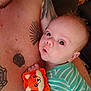 Asher is registered to the contest to win money with this photo: baby, infant, person, tattoo, toy, fox_toy, striped_clothing, adult, skin, face, hand, cute, holding, close_up, indoor, couch, child, expression, looking, playful