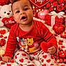 baby, balloons, candle, celebration, child, cute, decorations, flowers, gift_box, heart, holiday, pajamas, plush_toy, red_clothing, roses, smiling, socks, teddy_bear, valentines_day, white_blanket