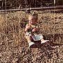 Nikkole is registered to the contest to win money with this photo: baby, barefoot, bow, casual_clothing, child, curious, dry_grass, grass, green_top, ground, nature, outdoor, playful, portrait, rocks, sitting, skirt, summer, sunlight, toddler
