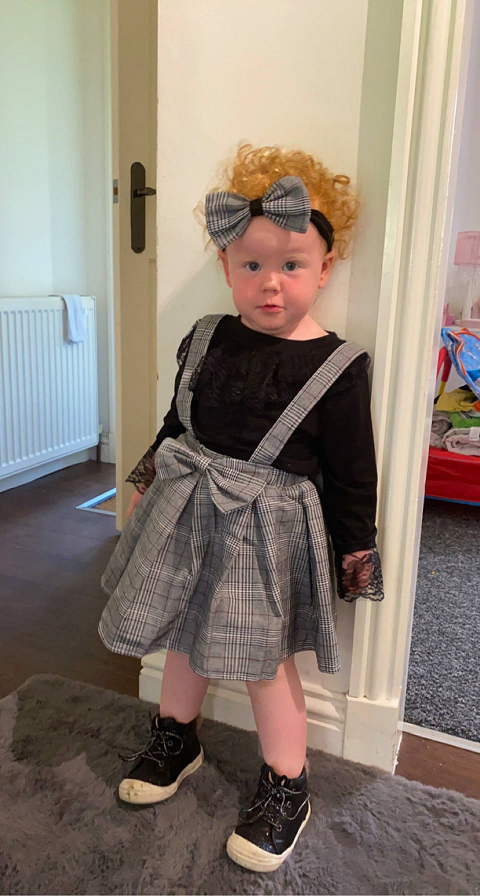 Arya Hopkins is registered to the contest to win money with this photo: child, day_dress, door, eyewear, fashion_design, formal_wear, hairstyle, hat, headwear, jewellery, knee, outerwear, pattern, person, sleeve, standing, street_fashion, tartan, toddler, trunk