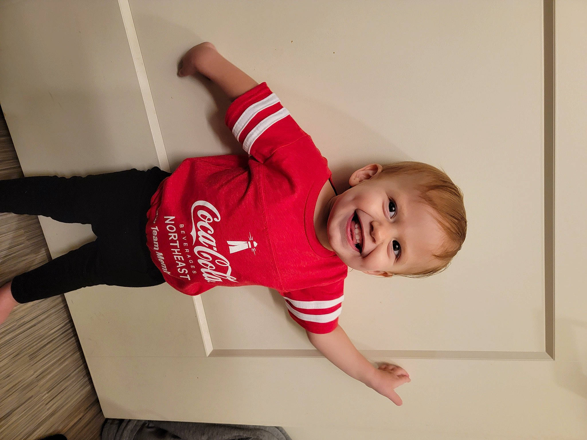 Thea is registered to the contest to win money with this photo: active_pants, baby_toddler_clothing, balance, comfort, elbow, floor, flooring, foot, happy, human_leg, joint, joy, knee, person, sleeve, smile, sock, sportswear, thigh, toddler