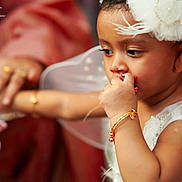 Rahmi joined the competition — help win amazing prizes! child, baby, angel_costume, white_feathers, headpiece, wings, bracelet, hand, adult, focus, portrait, cute, celebration, closeup, skin, face, sucking_thumb, jewelry, event, traditional_clothing