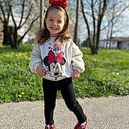 Mira participe au concours pour gagner de l'argent avec cette photo : child, girl, toddler, smile, headband, bow, minnie_mouse, sweatshirt, cartoon, outdoors, grass, trees, sneakers, red_shoes, standing, portrait, happy, sunlight, spring, sidewalk