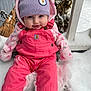baby, beanie, child, cold_weather, cute, face, frost, hat, infant, outdoor, person, pink_overalls, playful, portrait, sitting, smiling, snow, snowy_background, warm_clothing, winter_clothes