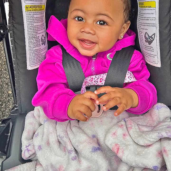 Journee is registered to the contest to win money with this photo: baby, child, smiling, stroller, seated, pink_clothing, blanket, portrait, indoor, happy, infant,  안전, face, hands, buckled, transportation, cute, social_media_screenshot, photography, headband