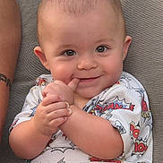 River joined the competition — help win amazing prizes! baby, child, smiling, face, hands, shirt, superhero, patterned_clothing, couch, seated, cute, happy, indoor, portrait, infant, skin, eyes, fingers, expression, casual