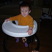 Alyena joined the competition — help win amazing prizes! baby, child, clothing, earrings, expression, face, floor, footwear, furniture, home, indoor, pants, person, purple_socks, smile, sweater, toddler, toy, walker, wood_floor