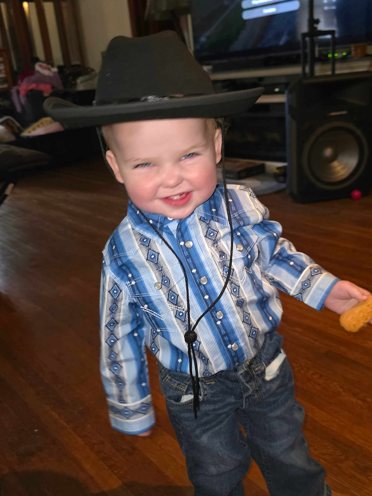 Wyatt joined the competition — help win amazing prizes! child, toddler, cowboy_hat, blue_shirt, jeans, smiling, indoor, wooden_floor, cookie, living_room, speaker, television, furniture, home, cute, portrait, person, happy, casual_clothing, playful