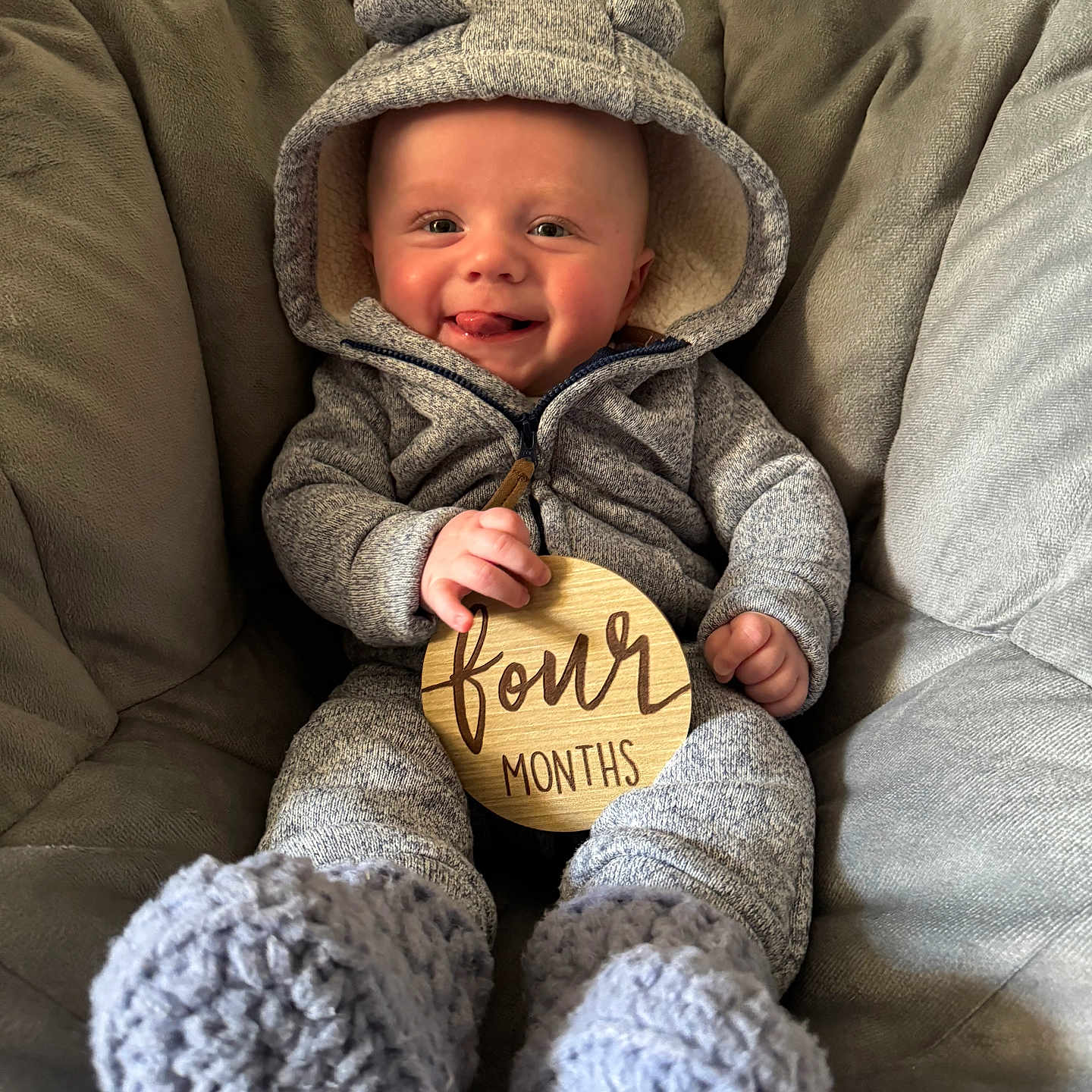 Jaxston is registered to the contest to win money with this photo: baby, bonnet, cap, clothing, coat, couch, face, furniture, hat, head, hood, hoodie, jacket, knitwear, pants, person, photography, portrait, sweater, sweatshirt