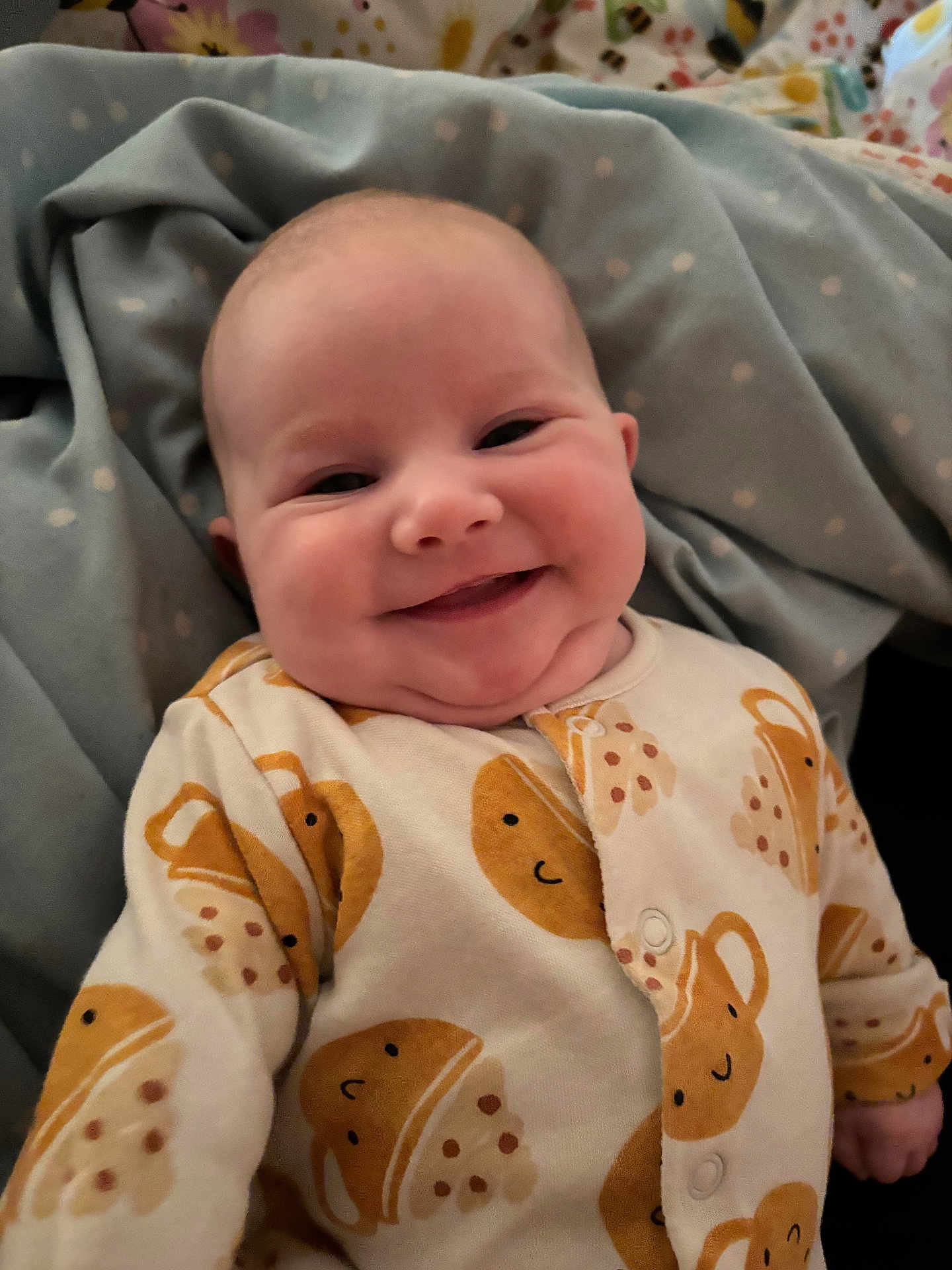 Flora joined the competition — help win amazing prizes! baby, smiling, onesie, cute, happy, infant, blanket, polka_dot, cozy, chubby_cheeks, face, child, sleepwear, patterned_clothing, soft, portrait, close_up, person, indoor, joyful