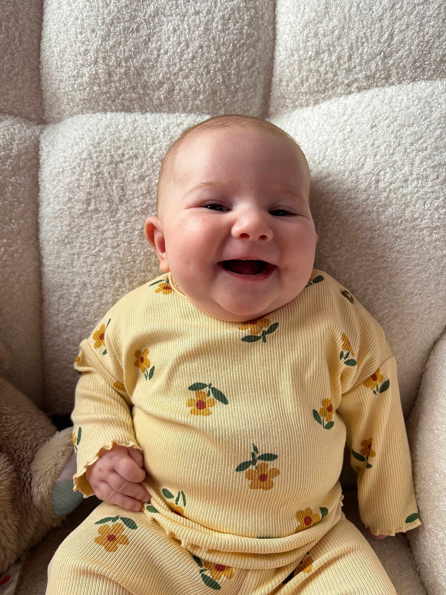 Flora joined the competition — help win amazing prizes! armchair, baby, casual_clothing, child, comfort, cozy, cute, expression, floral_pattern, happy, indoors, infant, person, portrait, seated, smiling, soft_texture, warm_lighting, yellow_outfit, young_child