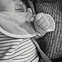 baby, infant, adult, black_and_white, close_up, smile, face, hand, sweater, knitwear, holding, love, heart_emoji, striped_clothing, cozy, portrait, cuddle, warmth, expression, bond