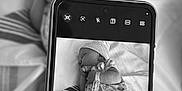 Maya joined the competition — help win amazing prizes! baby, newborn, sleeping, infant, hand, smartphone, black_and_white, blanket, hat, clothing, striped_blanket, socks, close_up, portrait, peaceful, indoor, bed, device, technology, photo_within_photo
