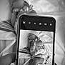 baby, newborn, sleeping, infant, hand, smartphone, black_and_white, blanket, hat, clothing, striped_blanket, socks, close_up, portrait, peaceful, indoor, bed, device, technology, photo_within_photo