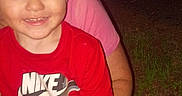 Ryder is registered to the contest to win money with this photo: child, turtle, red_shirt, nike_logo, smiling, outdoor, night, grass, adult_hands, person, animal, holding, happy, nature, cute, young_child, casual_clothing, portrait, flash_photo, human