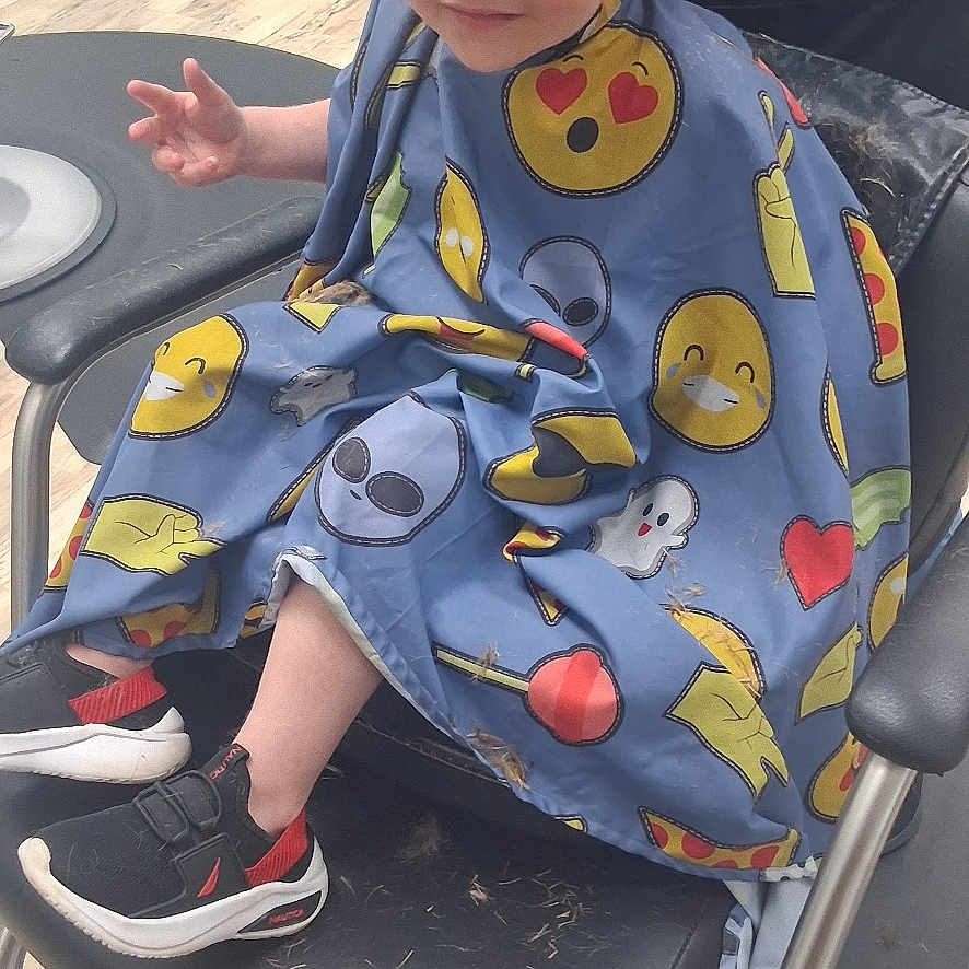 Ryder joined the competition — help win amazing prizes! toddler, child, haircut, barber_chair, stylist, hair, mohawk, cape, emoji, footwear, sneakers, floor, salon, hands, person, hairstyle, smiling, indoor, seat, cute