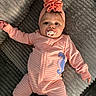 baby, infant, pink_onesie, headwrap, pacifier, seahorse_patch, lying_down, textured_surface, cute, child, portrait, soft_lighting, indoors, clothing, baby_fashion, sleepwear, adorable, young_child, headwear, cozy