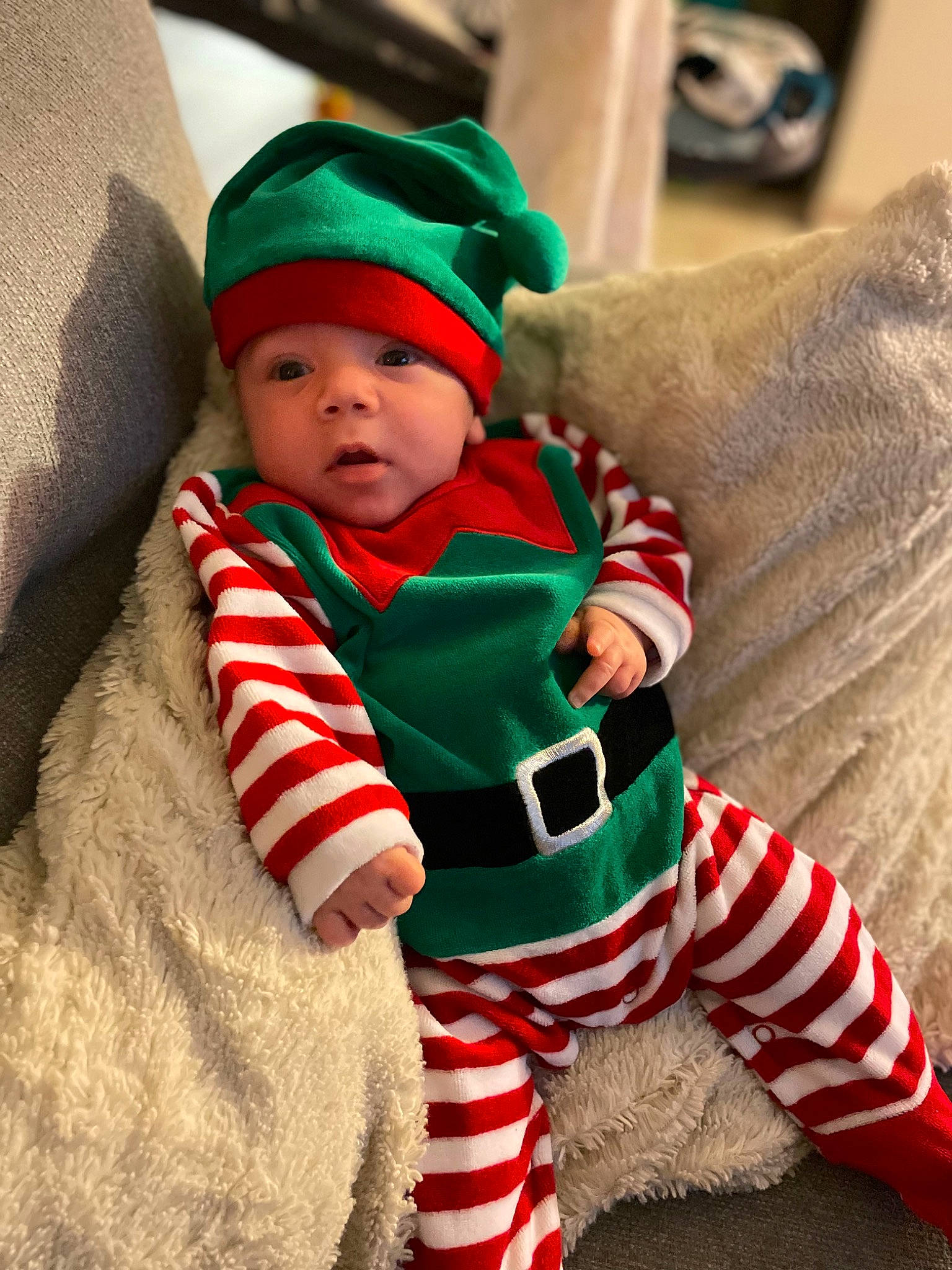 Nathan participe au concours pour gagner de l'argent avec cette photo : baby, baby_toddler_clothing, carmine, child, christmas, christmas_decoration, christmas_eve, comfort, event, face, fictional_character, fur, head, headwear, holiday, person, sitting, sleeve, sock, toddler