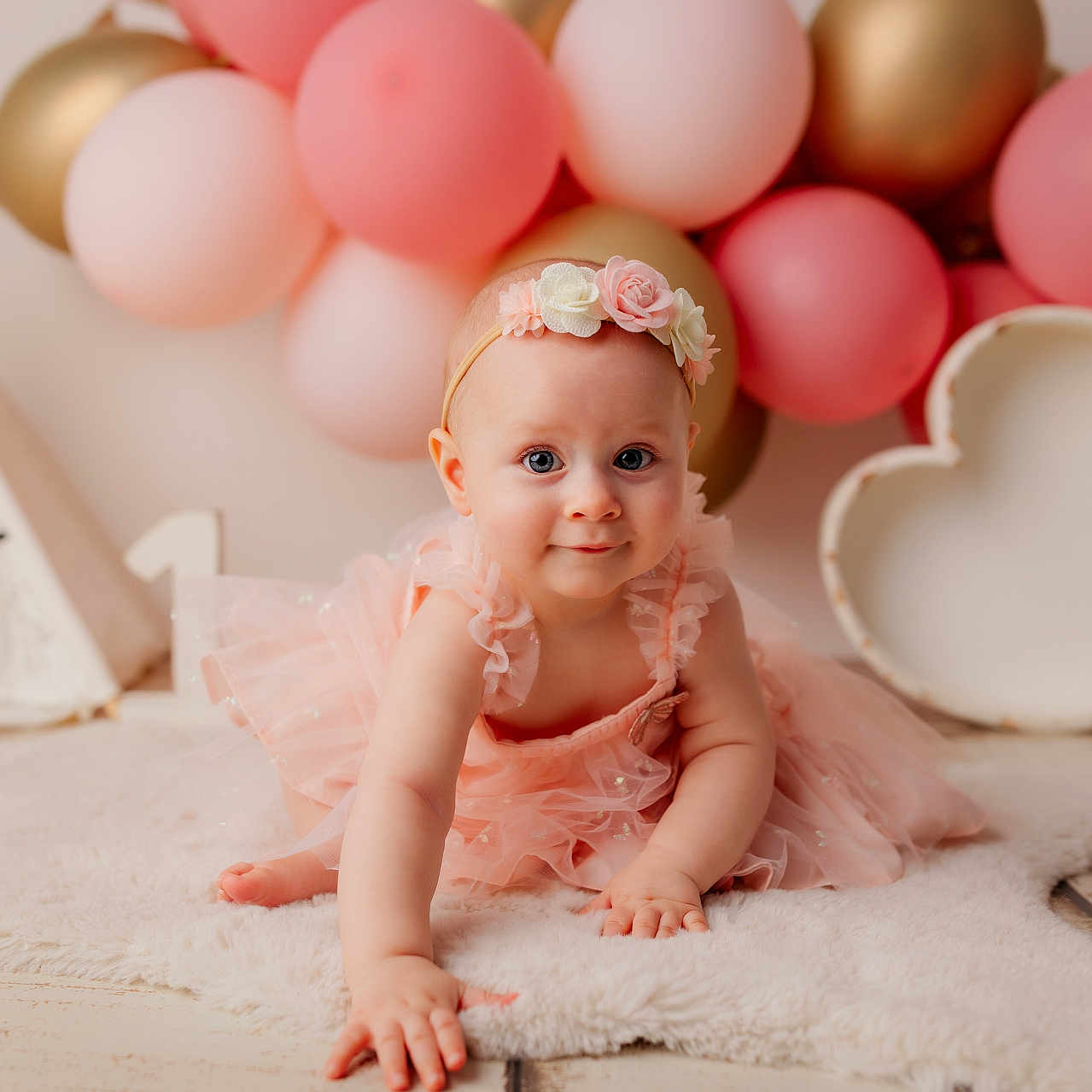 Helena participe au concours pour gagner de l'argent avec cette photo : baby, balloons, birthday, celebration, child, crawling, cute, decor, floor, floral_headband, gold_balloons, heart_shaped_prop, indoor, pink_balloons, pink_dress, portrait, smile, soft_lighting, teepee, white_rug