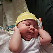 Askari joined the competition — help win amazing prizes! baby, sleeping, hat, yellow, white_clothing, infant, peaceful, cute, newborn, soft, blanket, closeup, portrait, hands, face, indoors, resting, child, cozy, toddler