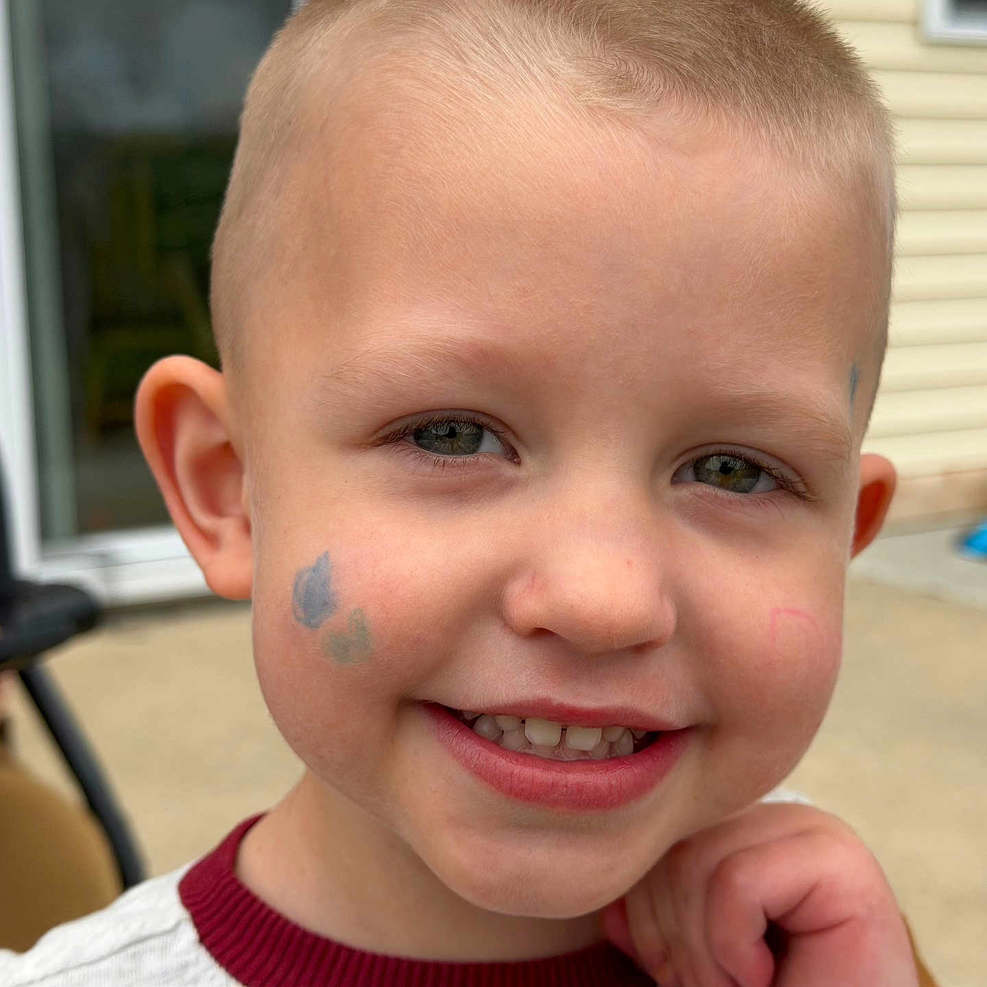 Maverick is registered to the contest to win money with this photo: child, boy, smile, face_paint, portrait, outdoor, short_hair, happy, person, casual, background_blur, daylight, skin, head, expression, young, cute, clothing, hand, eyes