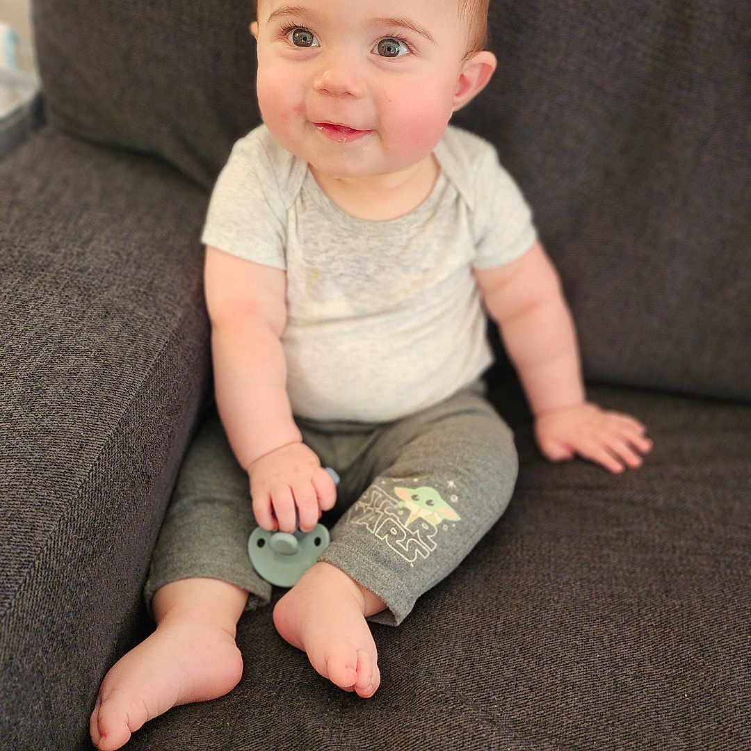 Aidan is registered to the contest to win money with this photo: baby, barefoot, bodypart, chair, clothing, couch, cushion, face, finger, furniture, hand, head, homedecor, jeans, pants, person, photography, portrait, sitting, t_shirt