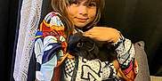 Louane a rejoint le concours — aidez-le/la à gagner de superbes lots ! child, bunny, animal, pet, cuddling, colorful_clothing, hoodie, indoor, couch, pillow, curtain, smile, young, cute, portrait, relaxed, furry, black_bunny, person, home
