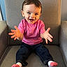 child, toddler, smiling, happy, sitting, armchair, pink_shirt, jeans, socks, indoor, portrait, cute, hands, face, person, baby, furniture, home, casual_clothing, young_child