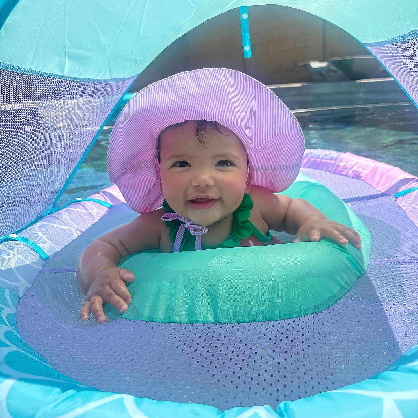 Aaliyah joined the competition — help win amazing prizes! architecture, baby, building, cap, clothing, face, hat, head, nature, outdoors, person, photography, pool, portrait, shelter, summer, swimmingpool, swimwear, tent, water