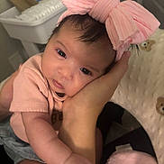 Nova is registered to the contest to win money with this photo: baby, infant, pink_bow, headband, cute, hand, arm, clothing, closeup, indoor, person, skin, face, eyes, adorable, newborn, soft, warm, resting, toddler
