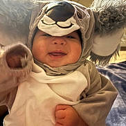 Nova is registered to the contest to win money with this photo: baby, blanket, child, clothing, costume, cuddly, cute, face, furniture, fuzzy_ears, hand, happy, hood, indoor, infant, koala, portrait, smile, soft_toys, warm