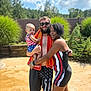 Amariah joined the competition — help win amazing prizes! family, baby, man, woman, outdoor, poolside, sunny, swimsuit, shorts, towel, glasses, smile, greenery, fence, sky, clouds, summer, trees, holding, happy