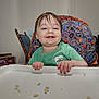 toddler, child, high_chair, smiling, happy, food, crumbs, green_shirt, space_theme, fabric, indoor, wooden_chair, person, cute, messy, feeding, baby, portrait, home, fun
