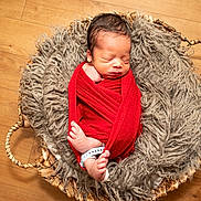 James joined the competition — help win amazing prizes! newborn, baby, sleeping, wrapped, red_blanket, basket, woven_basket, fluffy_fabric, gray_fabric, wooden_floor, infant, cozy, peaceful, foot, hand, portrait, indoor, cute, resting, soft_texture