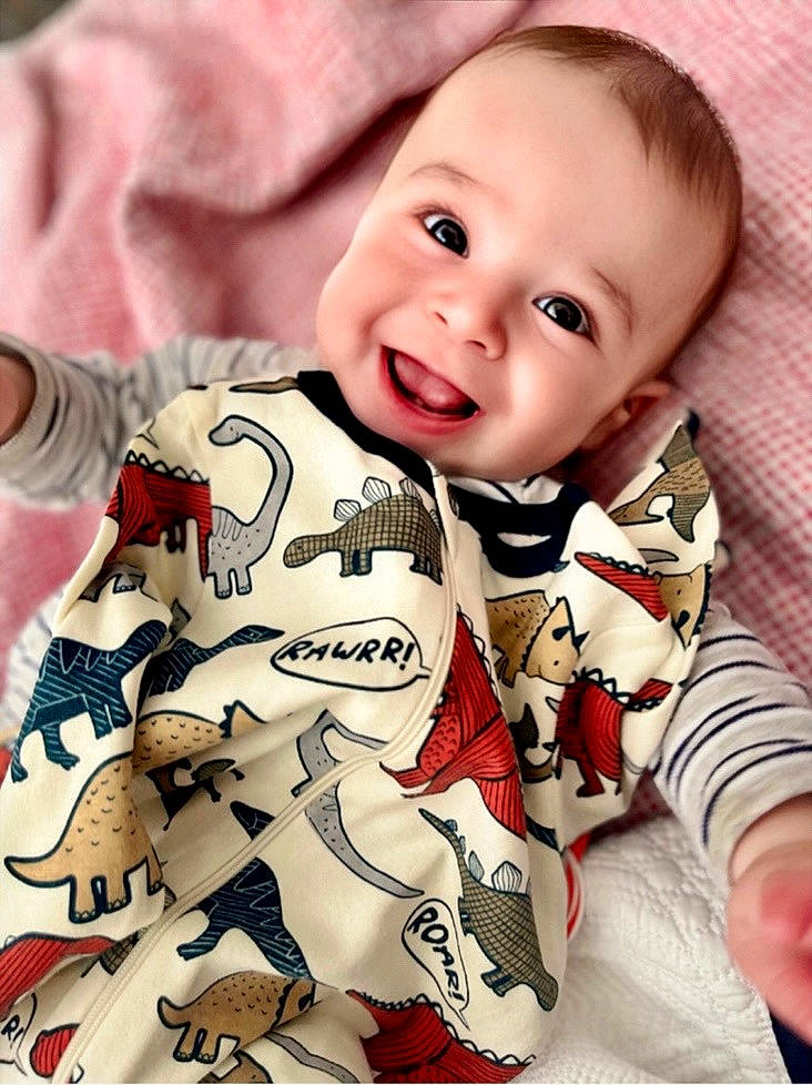 Flynn is registered to the contest to win money with this photo: baby, baby_toddler_clothing, beauty, cheek, child, collar, comfort, face, finger, happy, human, pattern, person, product, sitting, skin, sleeve, smile, t_shirt, textile