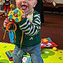 toddler, child, toy, playmat, book, indoor, happy, smiling, clothing, person, floor, colorful, baby, playtime, background, carpet, striped_sweater, jeans, sock, holding