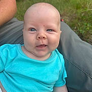 Waylon is registered to the contest to win money with this photo: baby, infant, child, person, blue_shirt, outdoor, nature, grass, greenery, smile, face, head, skin, eyes, young, cute, portrait, sitting, human, casual_clothing